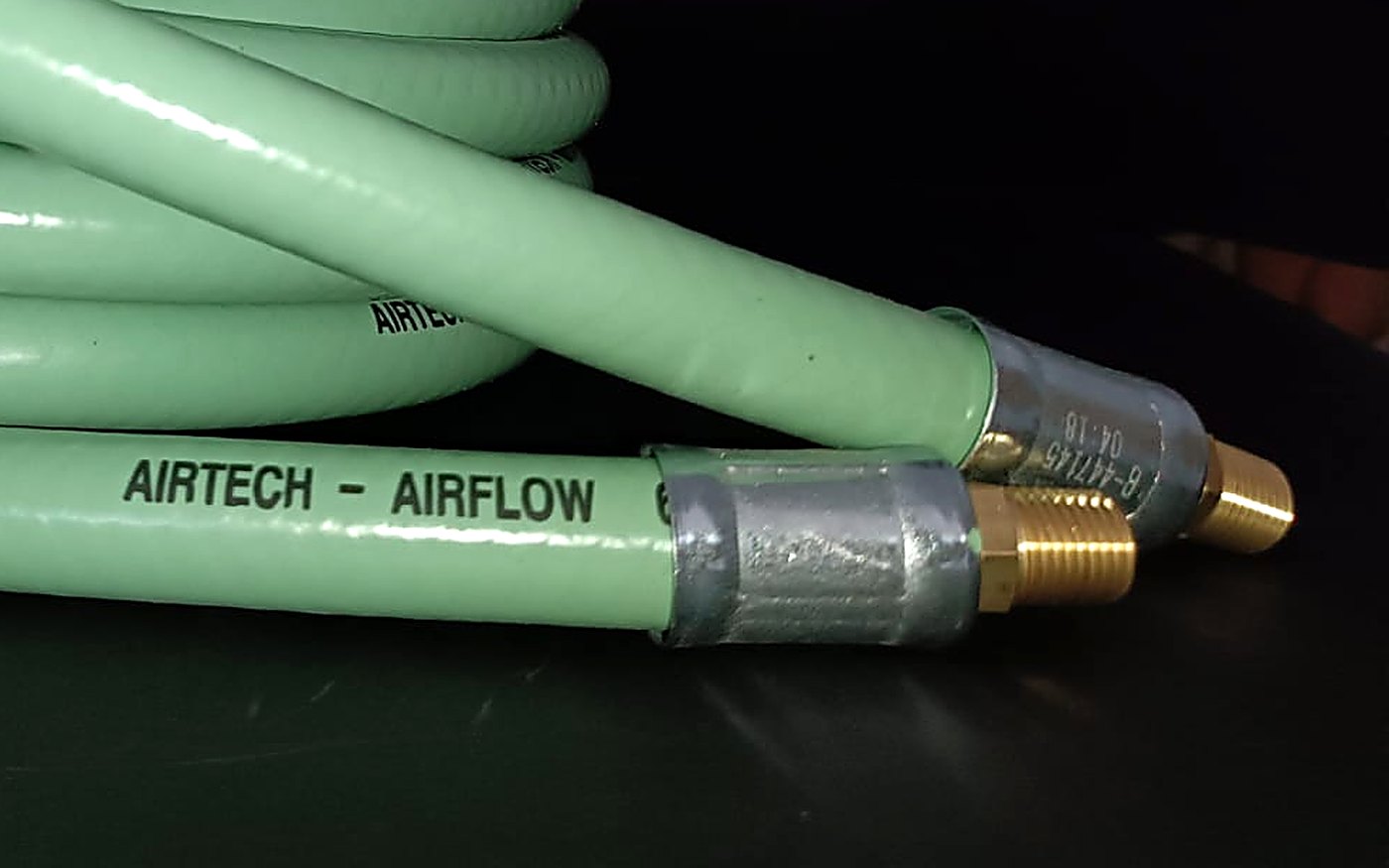 Detalle de los extremos de la manguera Airflow 65R: férula metálica engastada y fitting macho NPT de bronce
